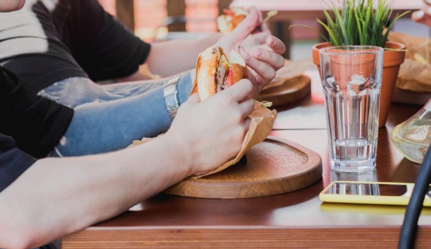 A group of people sitting at a table eating a hot dog.