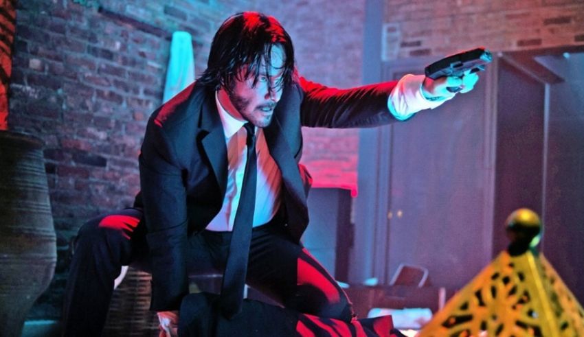 A man in a suit is holding a gun.