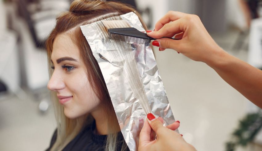 A woman is getting her hair colored in a salon.