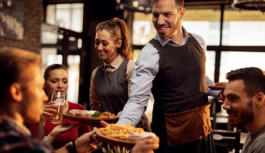 A waiter serving food to a group of people in a restaurant.