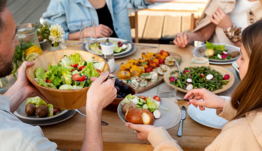 A group of people sitting around a table eating salad.