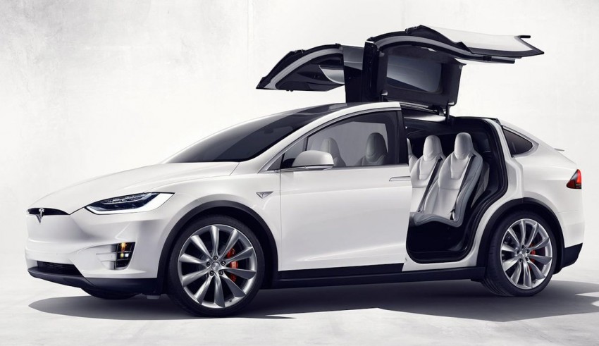 The tesla model x is shown with its doors open.