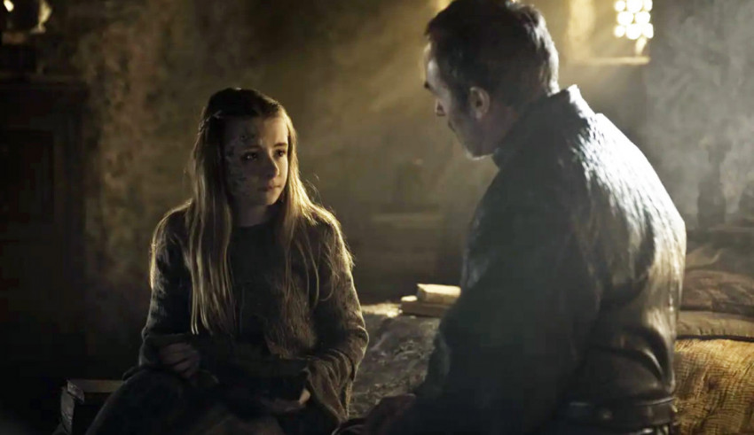 A man and a woman talking in a dark room.