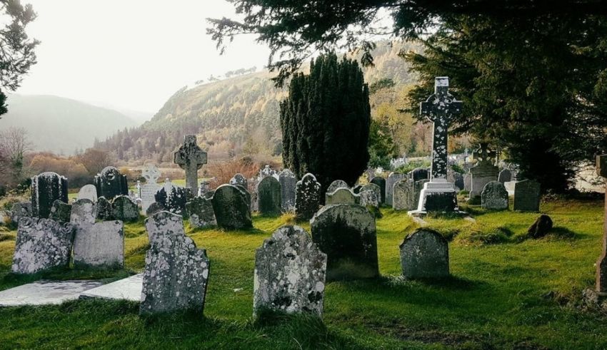 A cemetery with many tombstones in the grass.