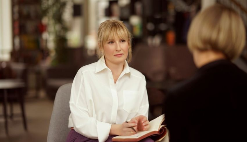 A woman sitting in a chair talking to another woman.