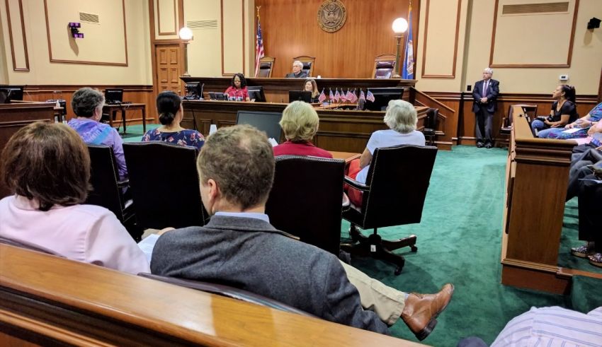 A group of people sitting in a courtroom.
