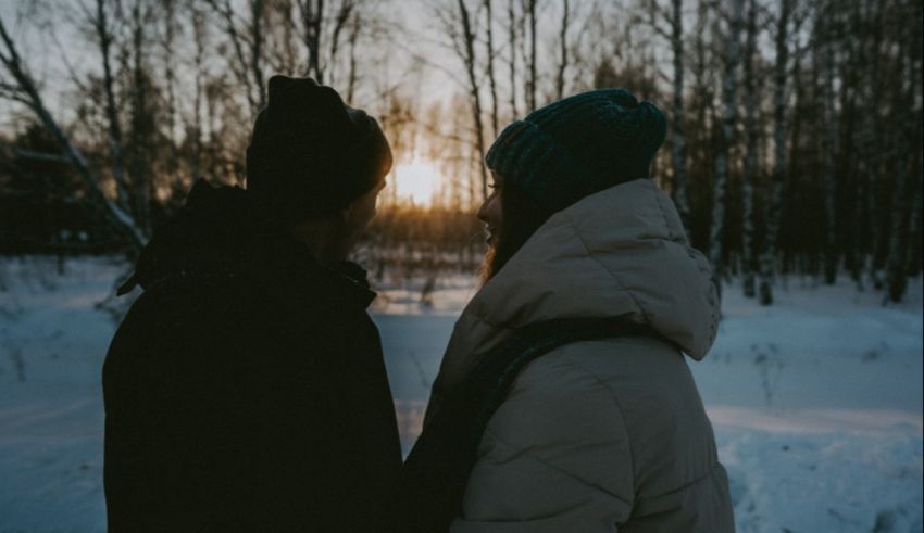 A couple looking at each other in the snow.