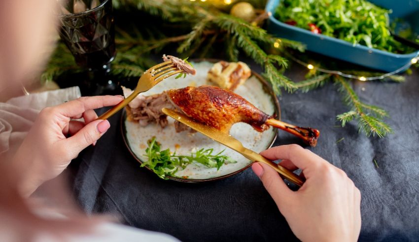 A woman is eating a plate of food with a fork.