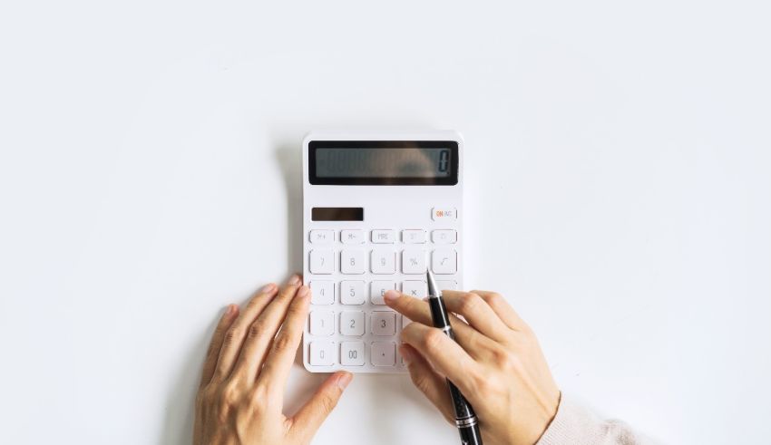 A woman's hand holding a calculator on a white background.