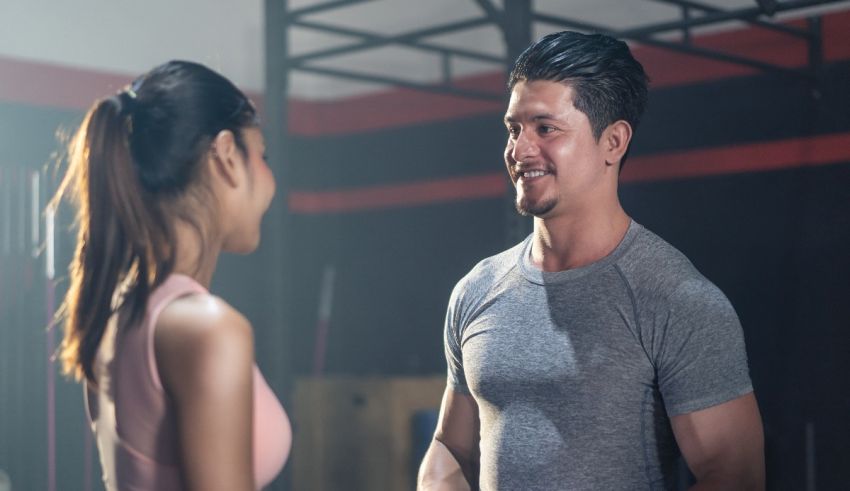 A man and woman talking in a gym.