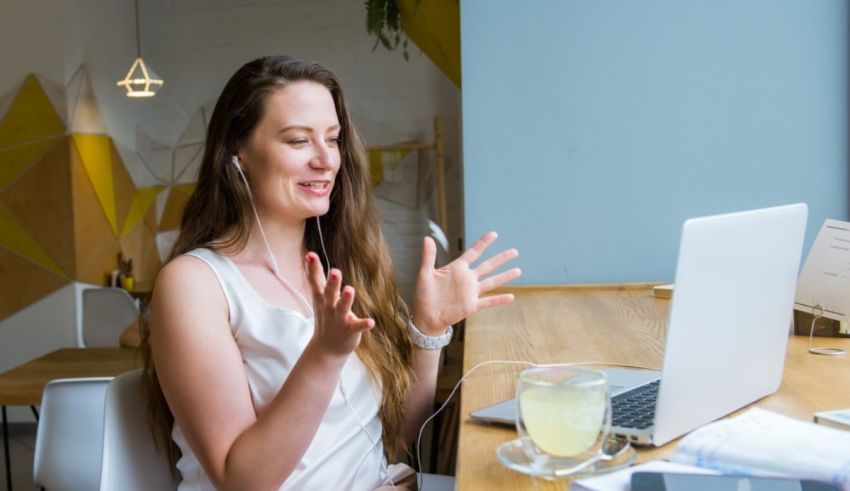 A woman sitting at a table with a laptop and a cup of coffee.