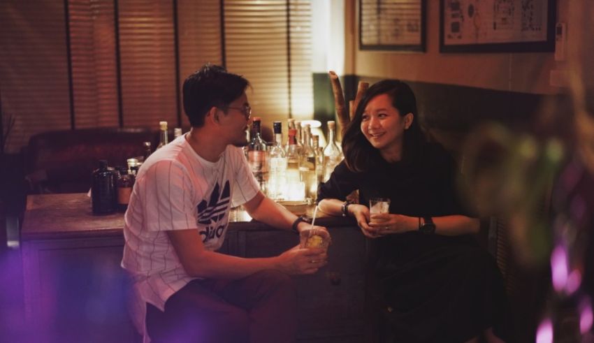 A man and woman sitting at a table in a bar.