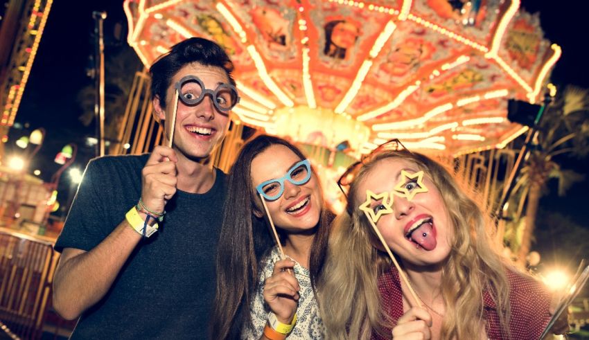 A group of friends posing for a photo at an amusement park.
