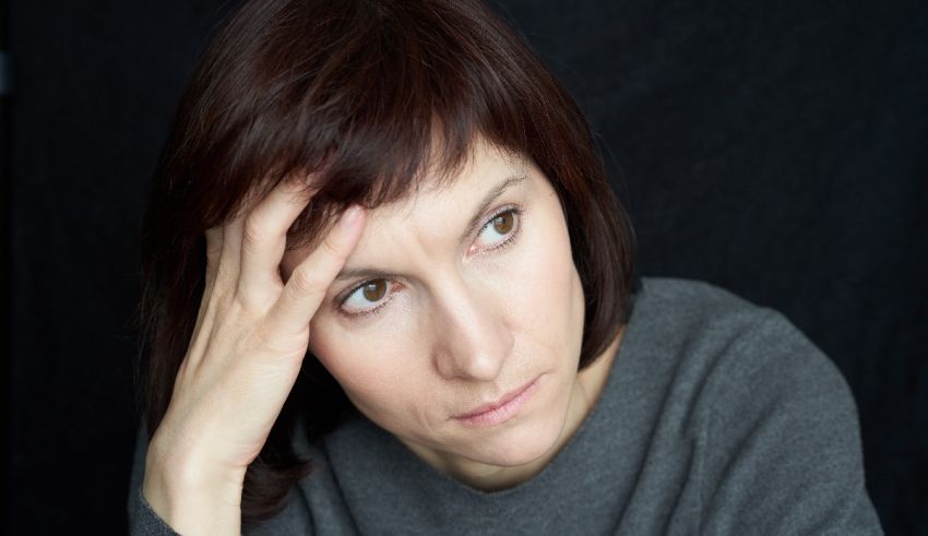 A woman with her hand on her head.