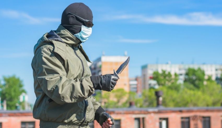 A man in a mask is holding a knife.