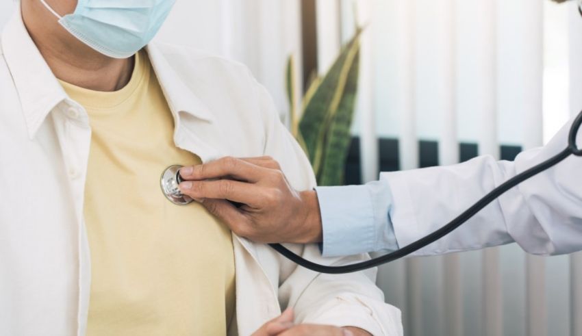 A doctor is checking a patient's chest with a stethoscope.