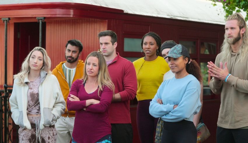 A group of people standing in front of a red train.