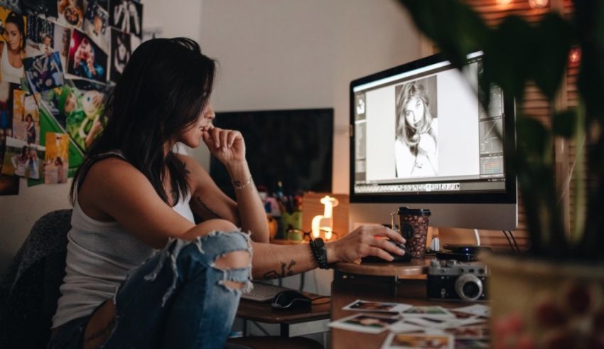 A woman sitting in front of a computer looking at a photo.