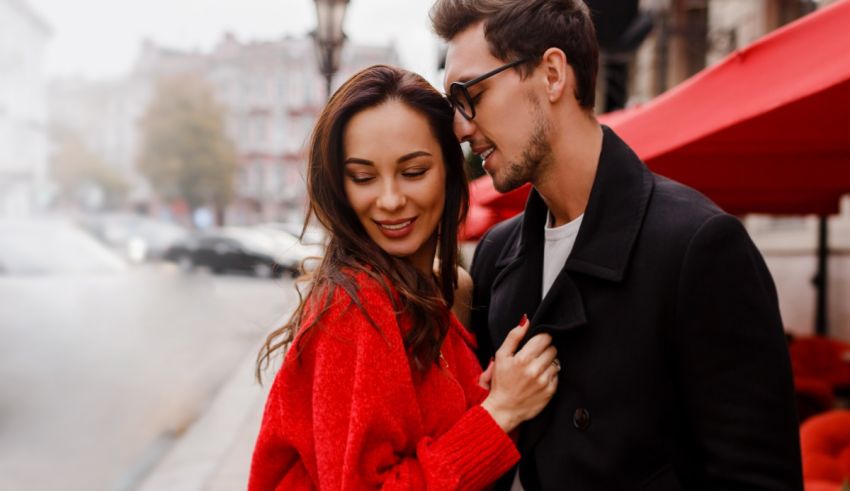 A man and woman hugging on a city street.
