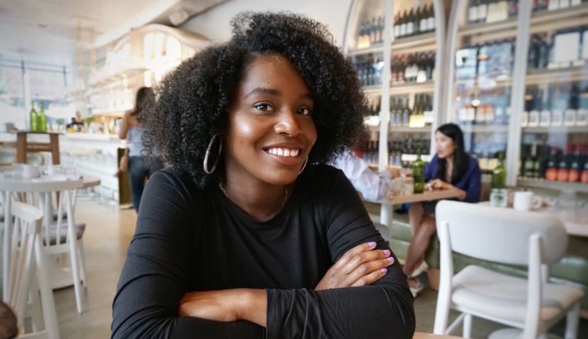 A black woman sitting at a table in a restaurant.