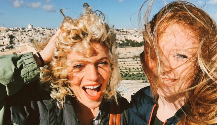 Two women posing for a picture in front of the city of jerusalem.