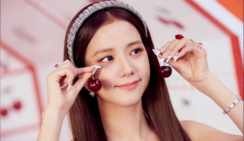 A woman is putting cherries on her eyes.