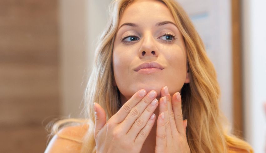 A woman is touching her face with her hands.
