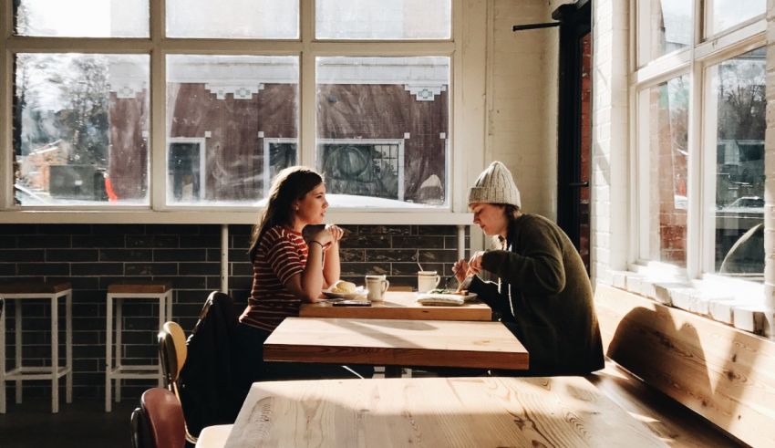 Two people sitting at a table in a cafe.