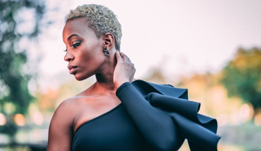 A black woman in a black dress posing for a photo.