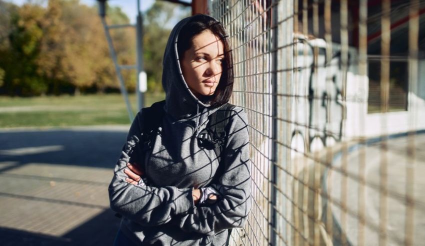 A young woman leaning against a fence.
