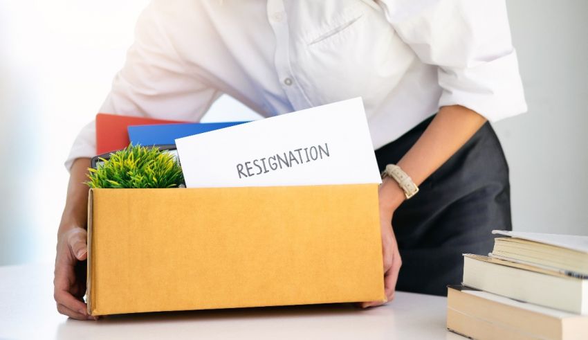 A woman is holding a box with papers in it.