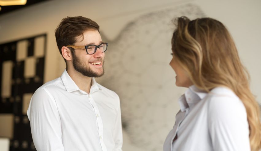 A man and woman are talking to each other in an office.