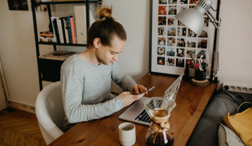 A man sitting at a desk using a laptop.