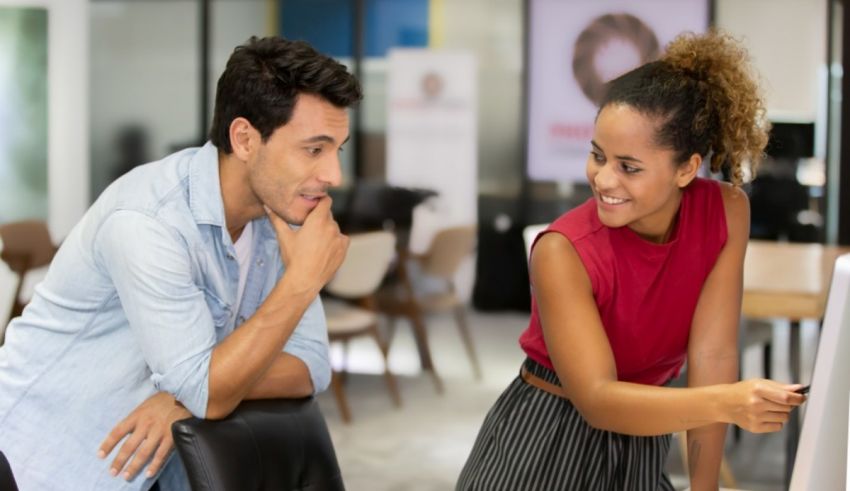 A man and woman looking at a computer screen.