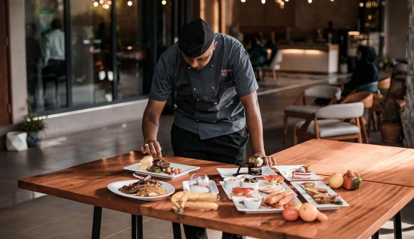 A chef preparing food on a table in a restaurant.