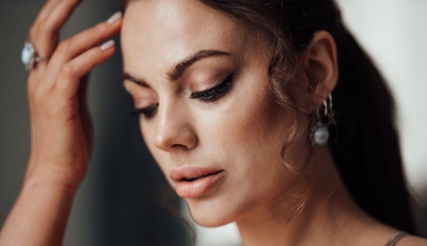 A woman is posing with her hand on her head.