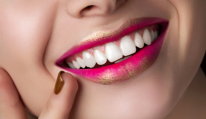 A close up of a woman's mouth with a pink lipstick on it.
