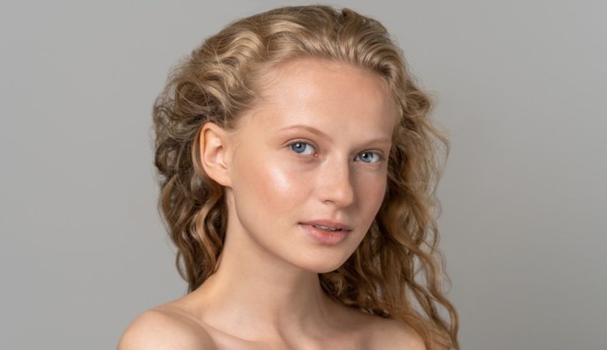 A young woman with curly hair posing for a photo.