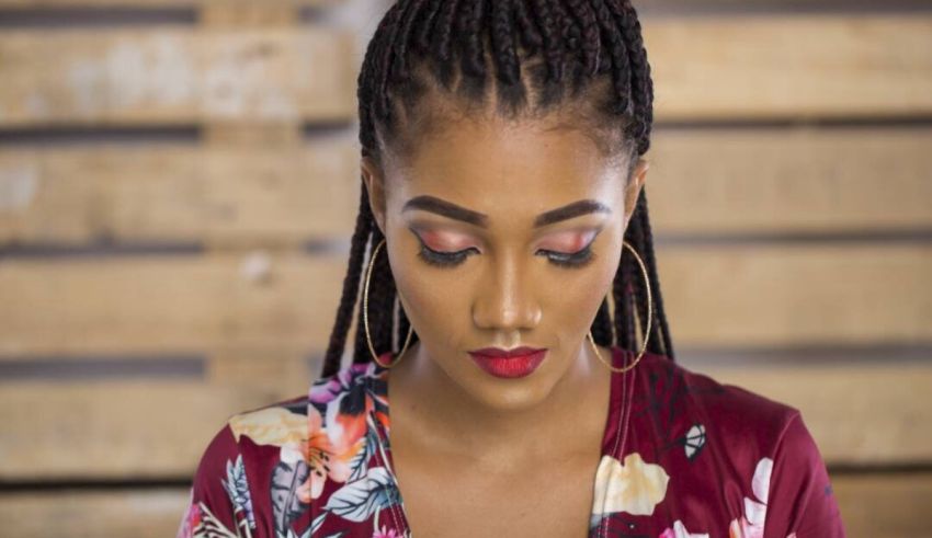 A woman with braided hair looking at her phone.