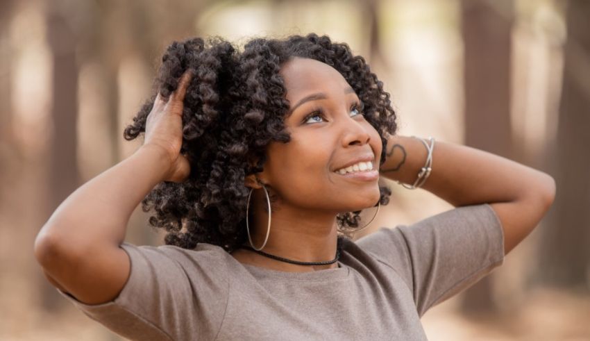 A black woman with curly hair looking up at the sky.