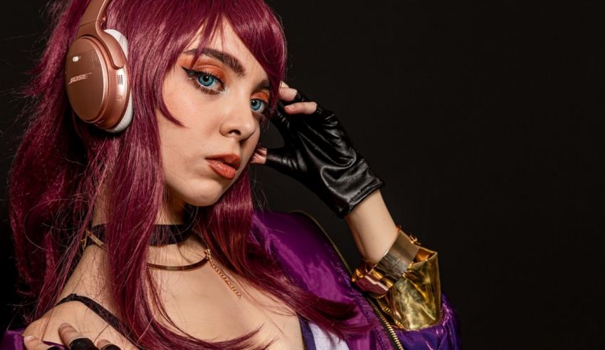 A woman with purple hair and headphones is posing for a photo.