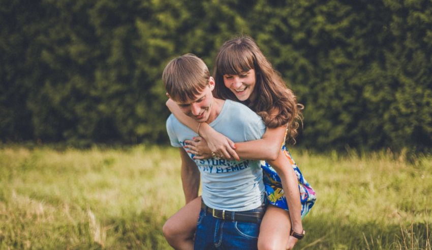 A man and a woman hugging each other in a field.