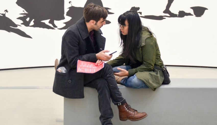 A man and a woman sitting on a bench.