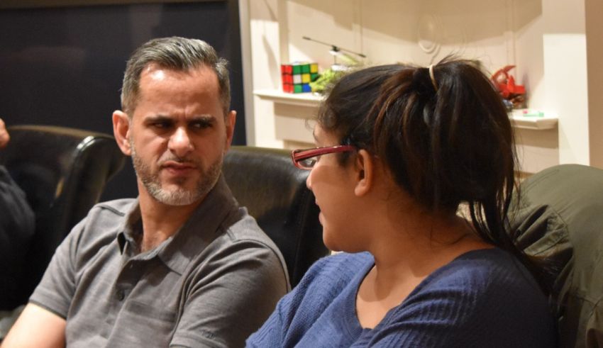 A man and woman sitting in a room talking to each other.