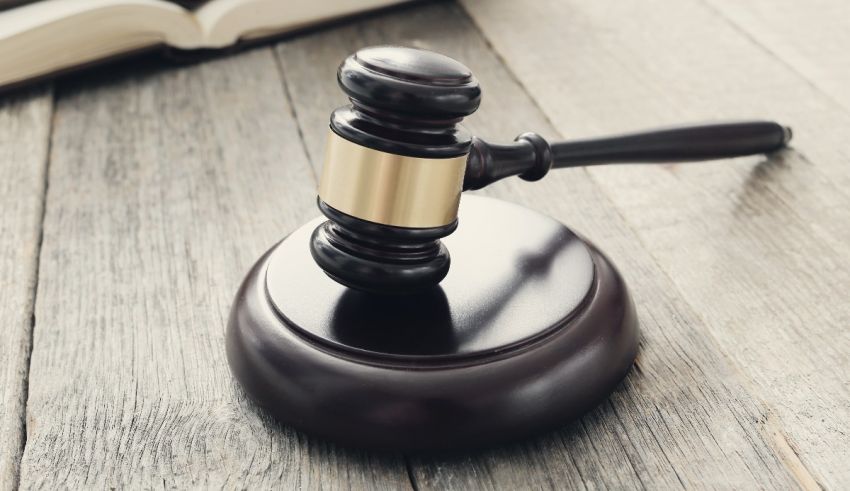 A judge gavel sits on top of an open book.