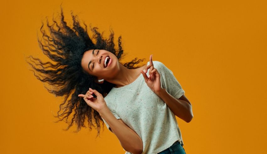 A young black woman is dancing with her hair flying in the air.