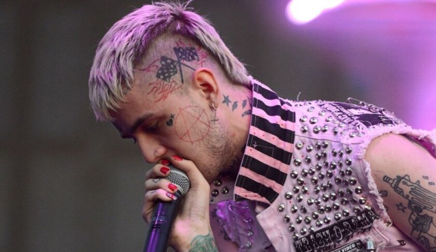 A man with tattoos singing into a microphone.