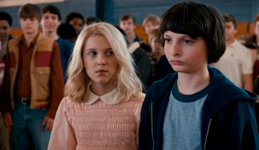 A boy and a girl standing in front of a crowd.