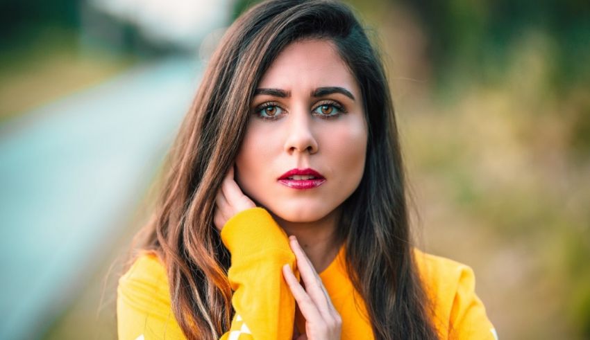A woman in a yellow shirt posing for a photo.