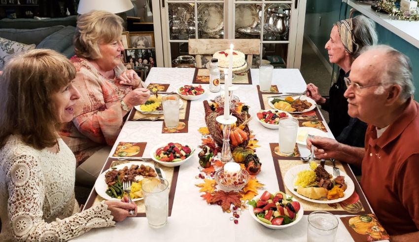 A group of people sitting around a table eating thanksgiving dinner.